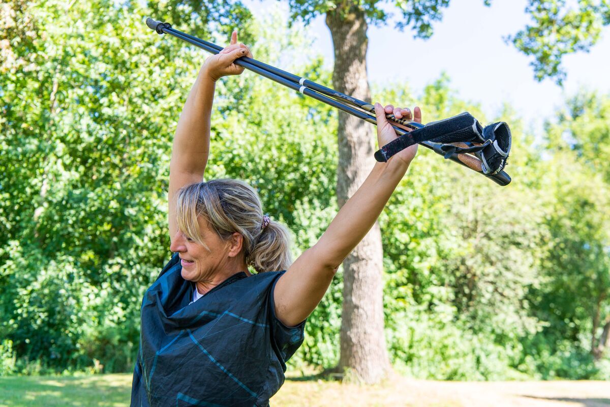 Eine Frau streckt sich zum Aufwärmen für den Sport in der Natur.