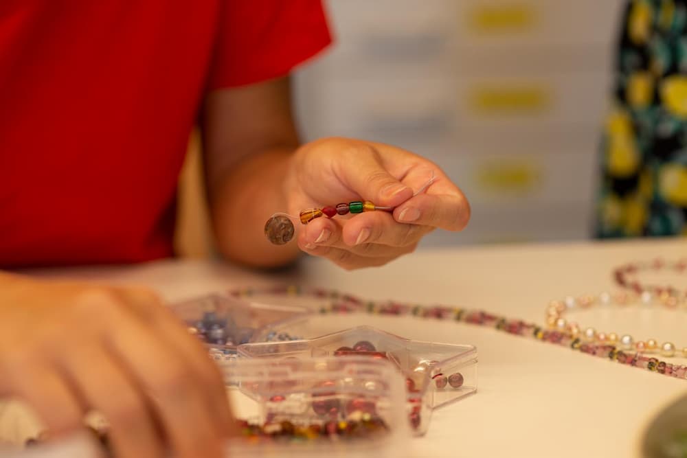 Kreatives Basteln von Perlenschmuck in der Gruppe